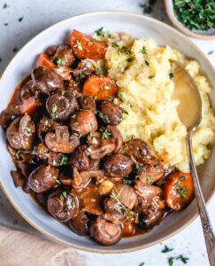 MUSHROOM ROOT VEGETABLE BOURGUIGNON WITH MASHED POTATOES